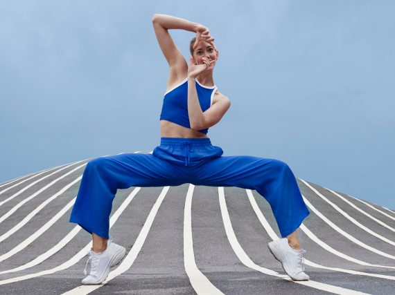 Frau in sportlicher Kleidung, die eine auffällige Pose einnimmt