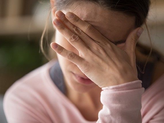 žena s rukou před obličejem