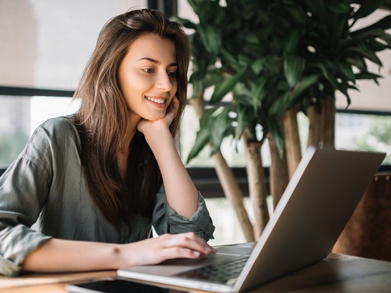 Usmívající se žena pracující na notebooku