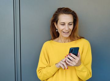 Frau verwendet Mobiltelefonieren zum Nachrichten senden.