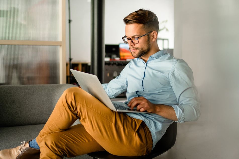 Young smiling Man typing on laptop