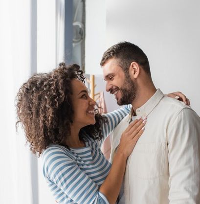 happy interracial couple hugging in bedroom