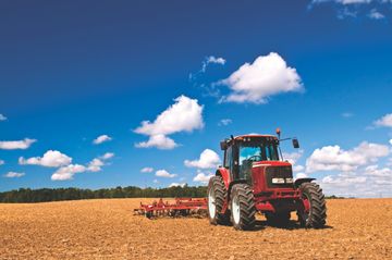 Tractor in plowed field Absatz-Leasing-Nutzfahrzeuge