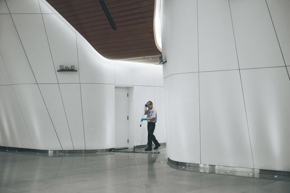 Muž vytírá vstupní halu kancelářské budovy