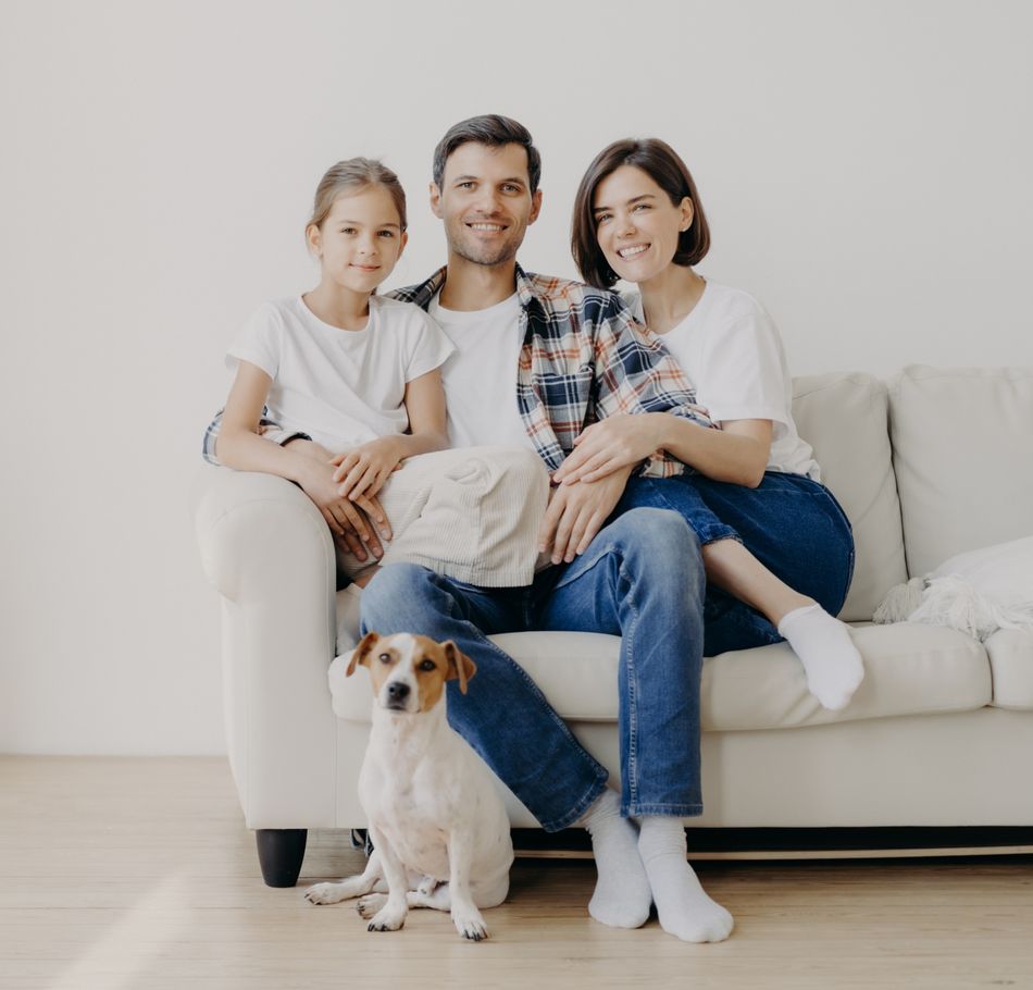Horizontal view of three friendly family members and small pedigree dog pose at camera for making memorable photography. Dauther spends free time with mother and father, have good day at home