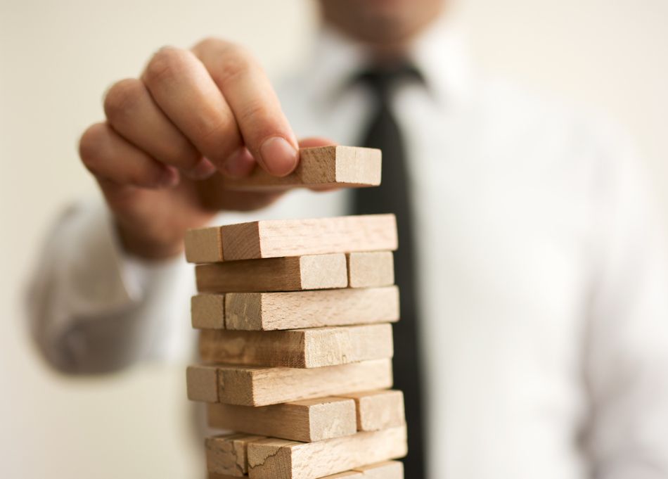 Businessman putting last block to the tower Veranlagung selbst gestalten