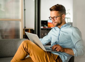 Young smiling Man typing on laptop