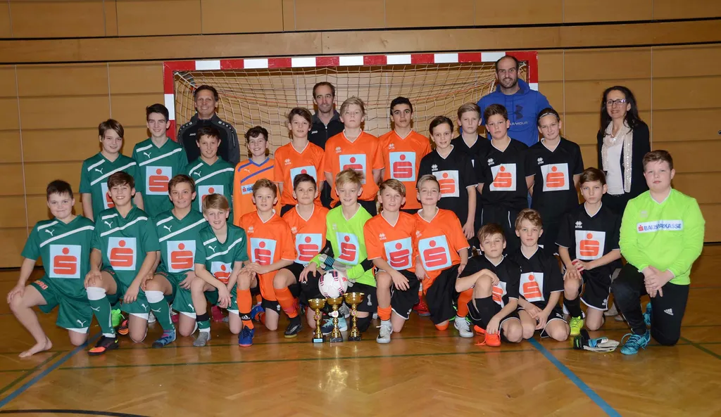 Gruppenbild von Kinder im Turnsaal mit Sparkasse trikot und Pokal