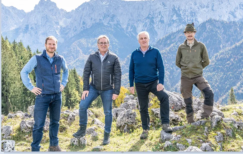 4 sportlich gekleidete Personen stehen auf einem Berg