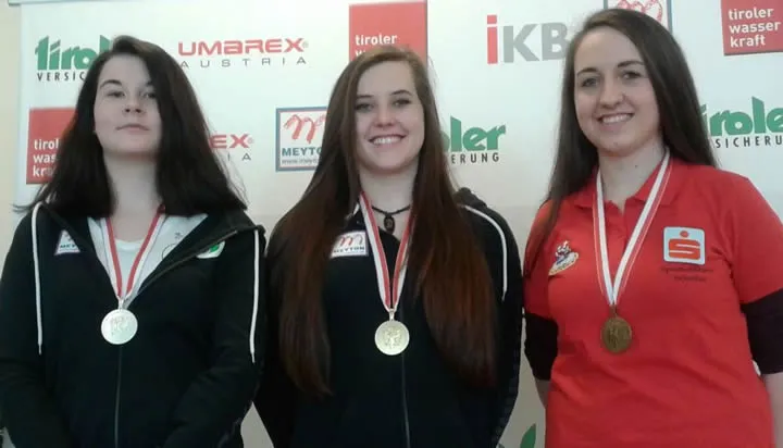 drei Frauen mit Medaille um den Hals lachen in die Kamera