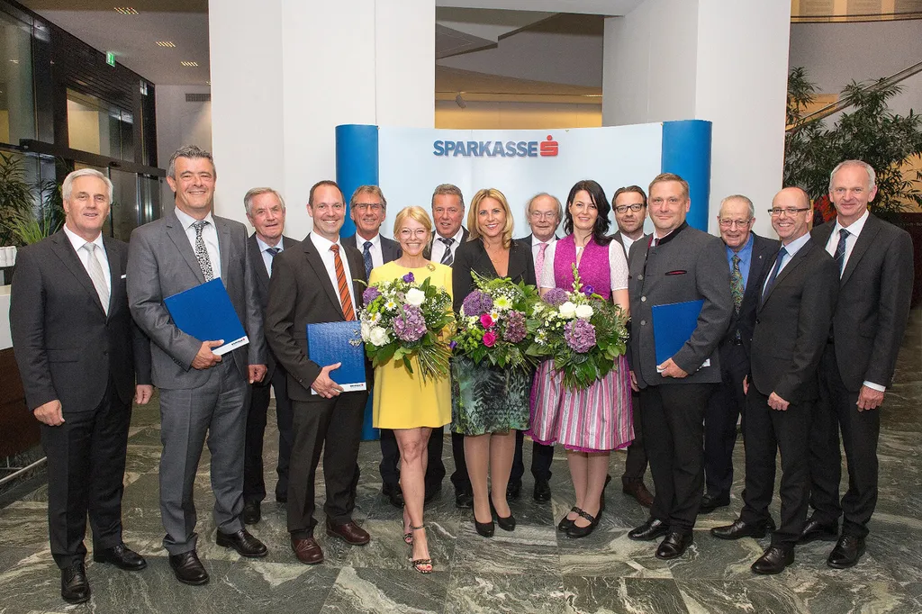 Frauen halten Blumen in der Hand und Männer halten Auszeichnungen in der Hand