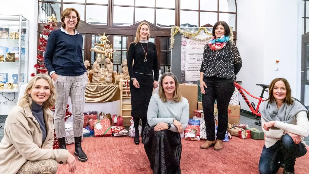 6 Damen lächeln in die Kamera bei weihnachtlicher Kulisse