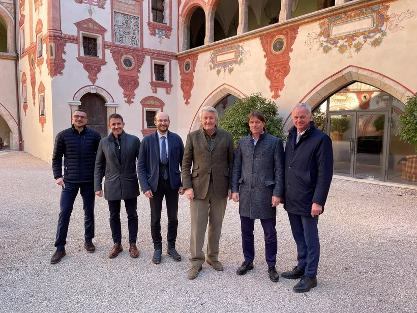 6 Herren stehen im Innenhof und lachen in die Kamera