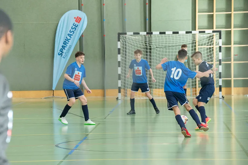 Buben spielen in der Halle Fußball