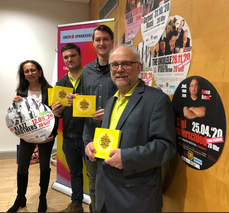 vier Personen halten Werbung in die Kamera