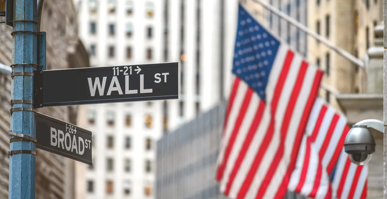 Straßenschild Wall Street - im Hintergrund US-Flaggen