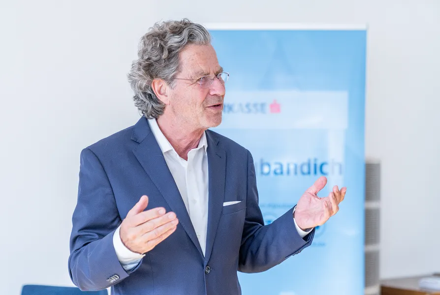 Herr in Anzug gestikuliert und redet