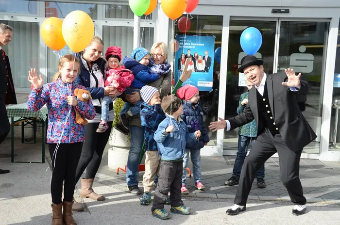 Kinder mit Luftballon in der Hand und tanzender Mann