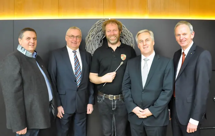 fünf Männer lachen stehend in die Kamera