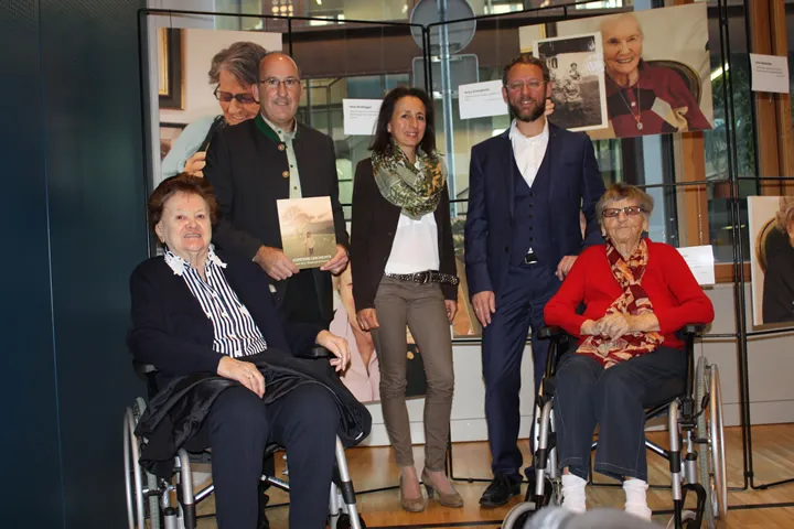 zwei Frauen im Rollstuhl und zwei Männer mit einer Frau stehend 