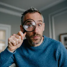 Muž vyhľadávajúci s lupou