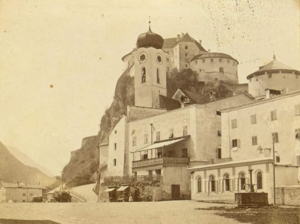 Gründungsjahr 1877 – links der Sitz der Sparkasse Kufstein im 1. Stock des Traubenwirtshauses im Eckhaus Oberer Stadtplatz/Unterer Stadtplatz Nr. 24.