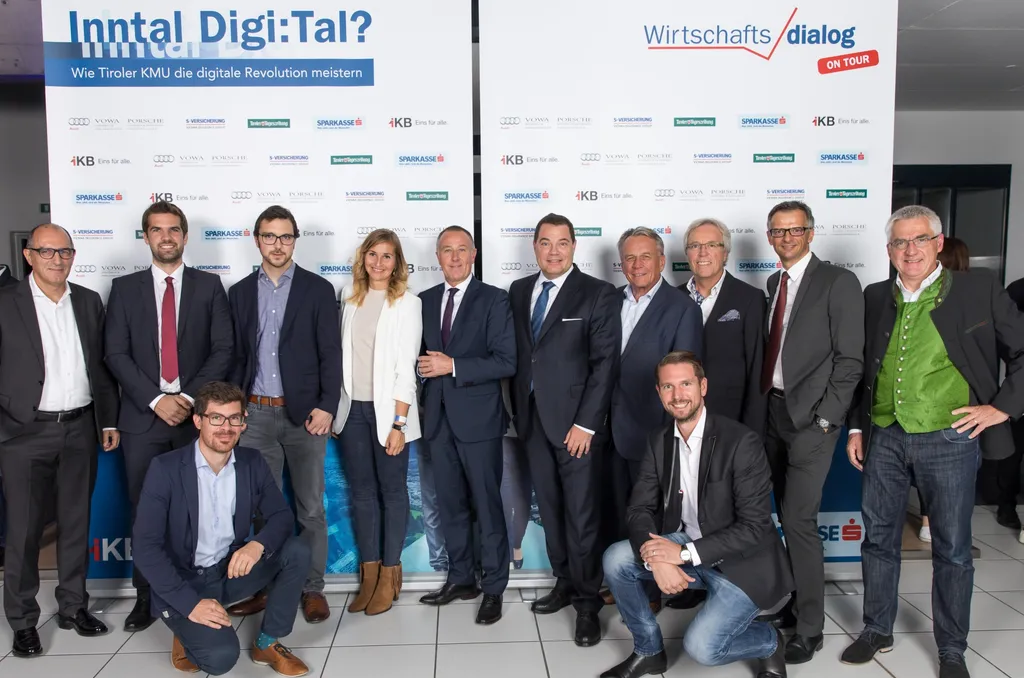 stehende Männer und eine Frau lachen in die Kamera 