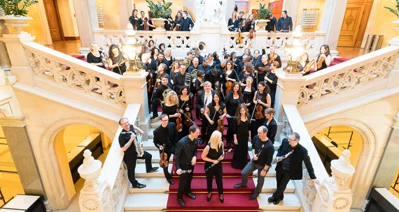 Mitglieder eines Orchester stehen auf einer Stiege