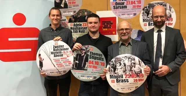 vier Männer halten Kreis mit Kultur-Highlights Programm in der Hand