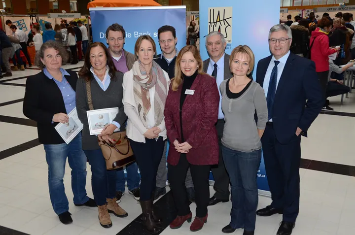 viele Personen schauen stehend in die Kamera