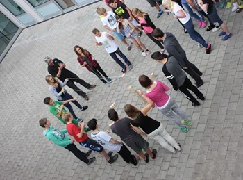 stehende Personen in eine Kreis halten eine Schnur