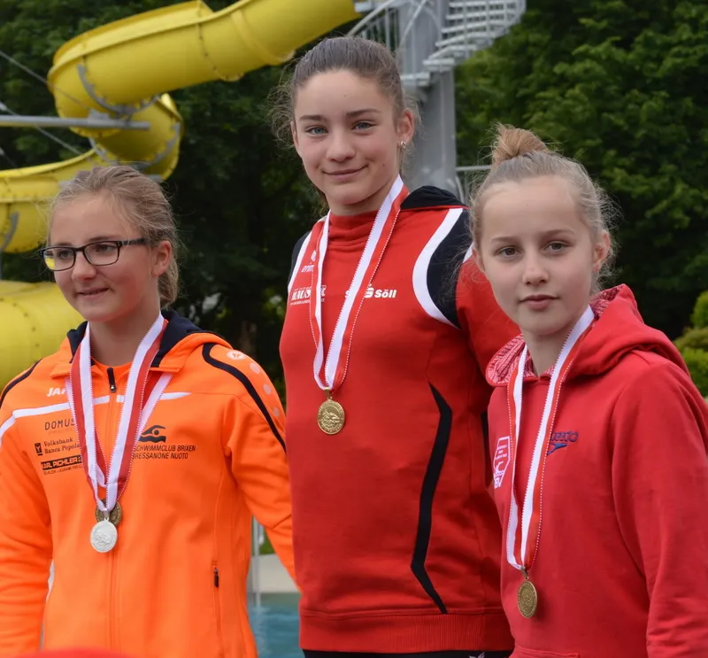 drei Mädchen mit Medaille um den Hals 