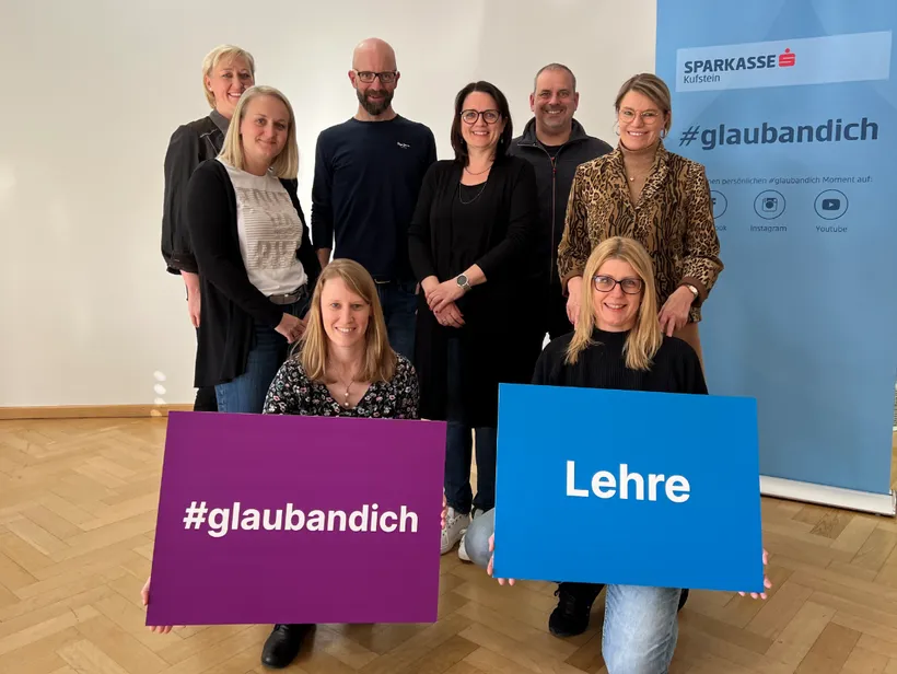 junge Menschen in einem Raum posieren mit zwei Schildern mit der Aufschrift #glaubandich Lehre