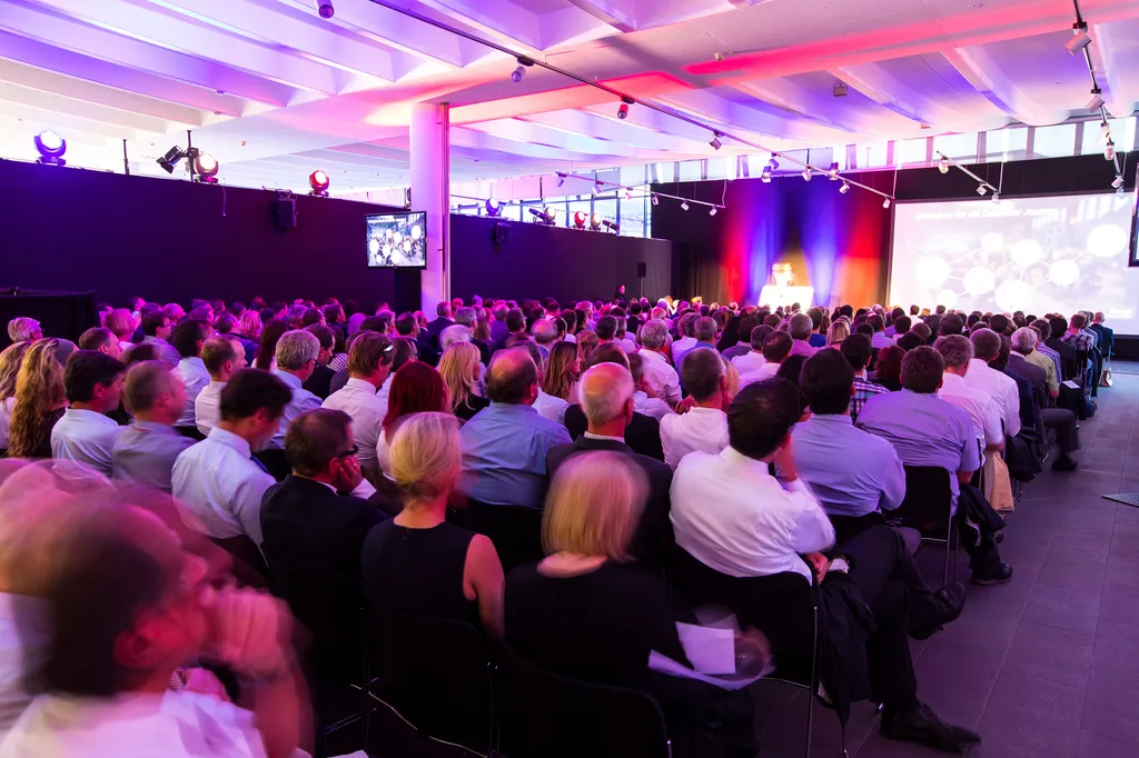 schauendes Publikum auf Bühne von hinten fotografiert 