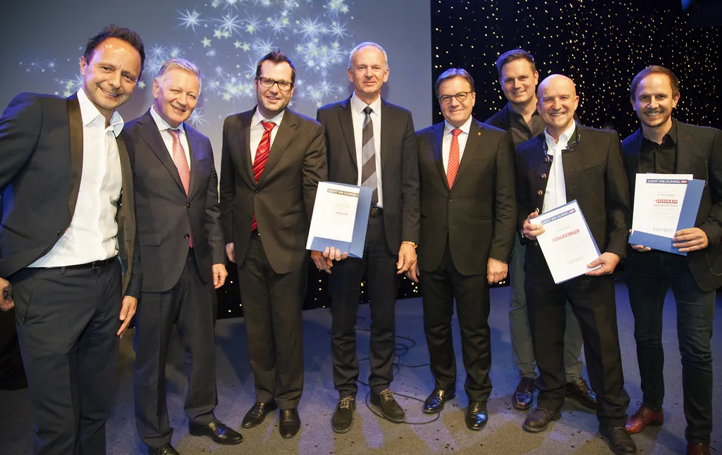 acht stehende Männer wovon drei Männer eine Urkunde in der Hand halten
