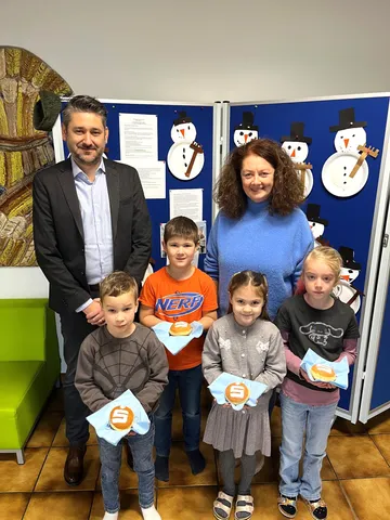 Mann in Business-Kleidung mit Frau und 4 Kinder mit Faschingskrapfen