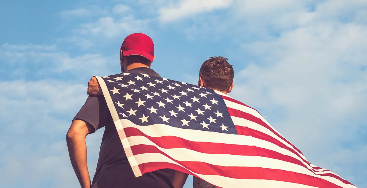 Zwei Männer, die auf ihrem Rücken die amerikanische Flagge halten