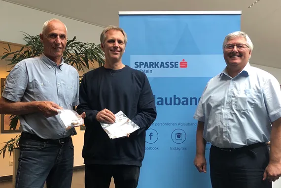 drei Herren posieren vor dem #glaubandich Aufsteller