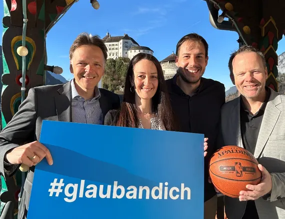4 Personen zeigen einen Ball und ein #glaubandich-Schild in die Kamera