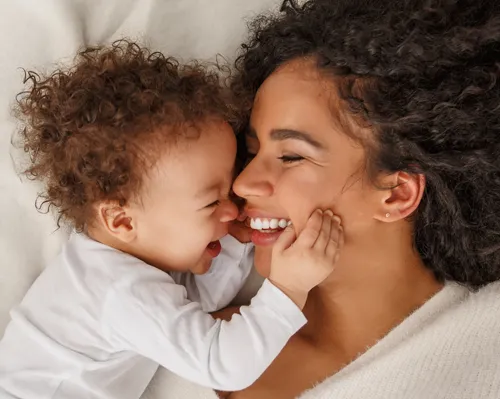 Mutter und Baby kuscheln und lachen