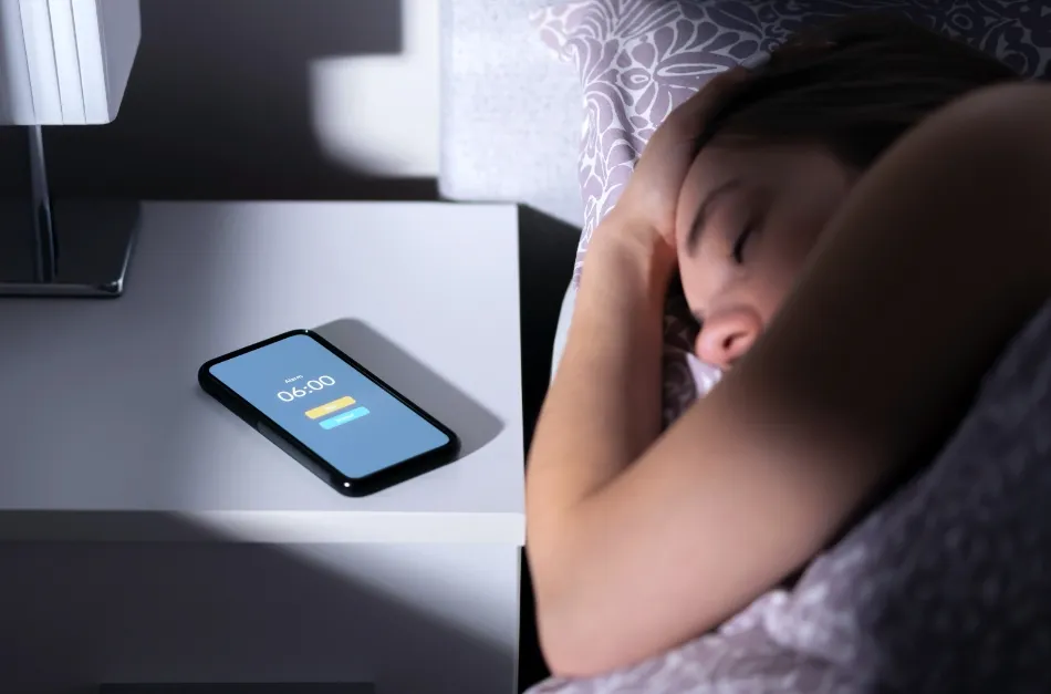 Žena v posteli s mobilním telefonem
