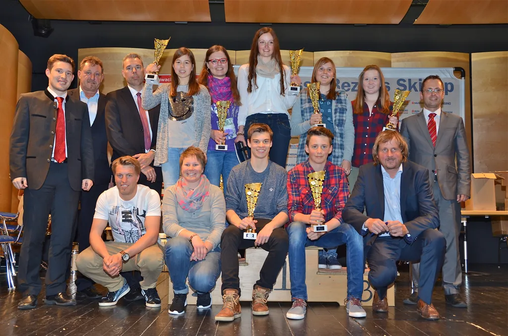 Jugendliche mit Pokal in der Hand und stehende Männer