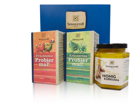 Geschenkbox der Marke Sonnentor gefüllt mit zwei Sorten Tee und einem Glas Honig