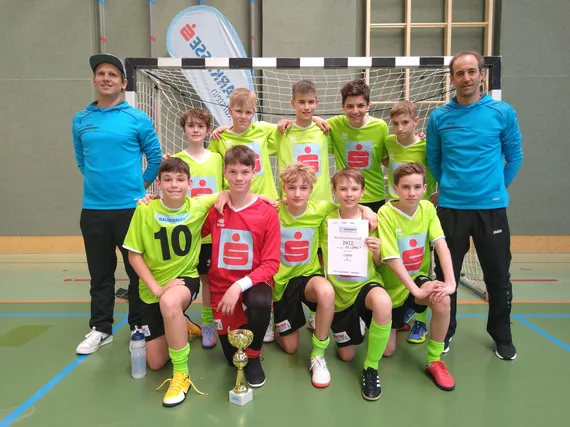 Gruppenfoto vor dem Tor mit Urkunde