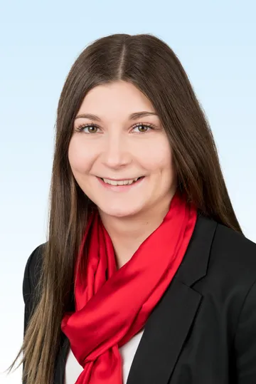 junge Frau mit Blazer und rotem Schal lächelt in die Kamera