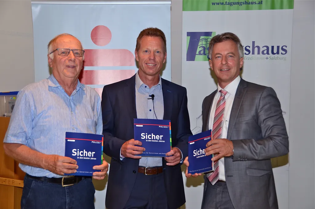 drei stehende Männer mit Polizei Prospekt in der Hand 