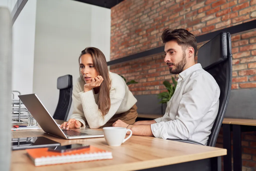 Zwei junge Geschäftsleute diskutieren gemeinsam beim Brainstorming im Büro