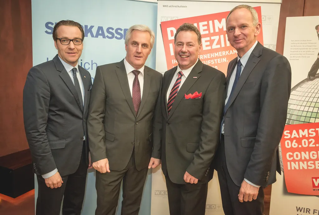 vier stehende Männer lachen in die Kamera