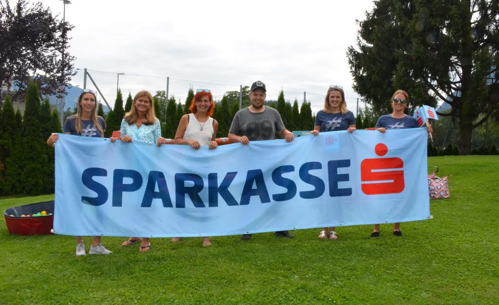 sechs Personen halten das Sparkasse Transparent 