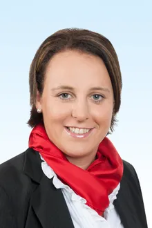 Dame mit rotem Schal lächelt in die Kamera